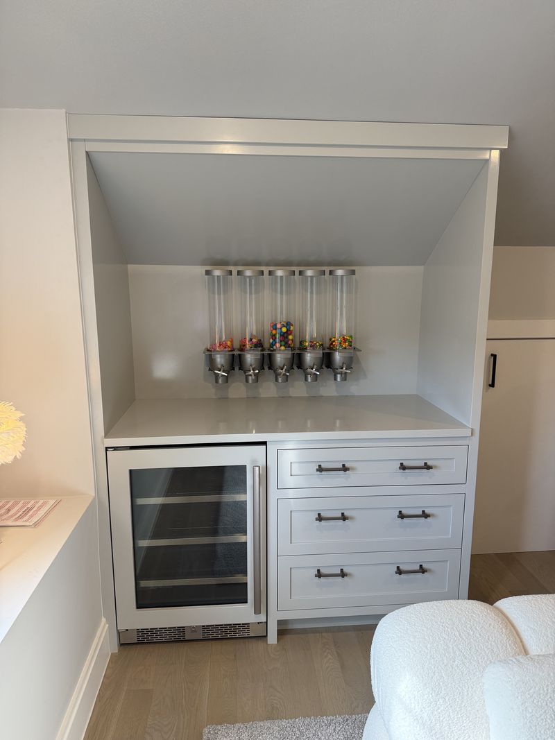 Custom beverage bar cabinetry with stone counter and wine refrigerator