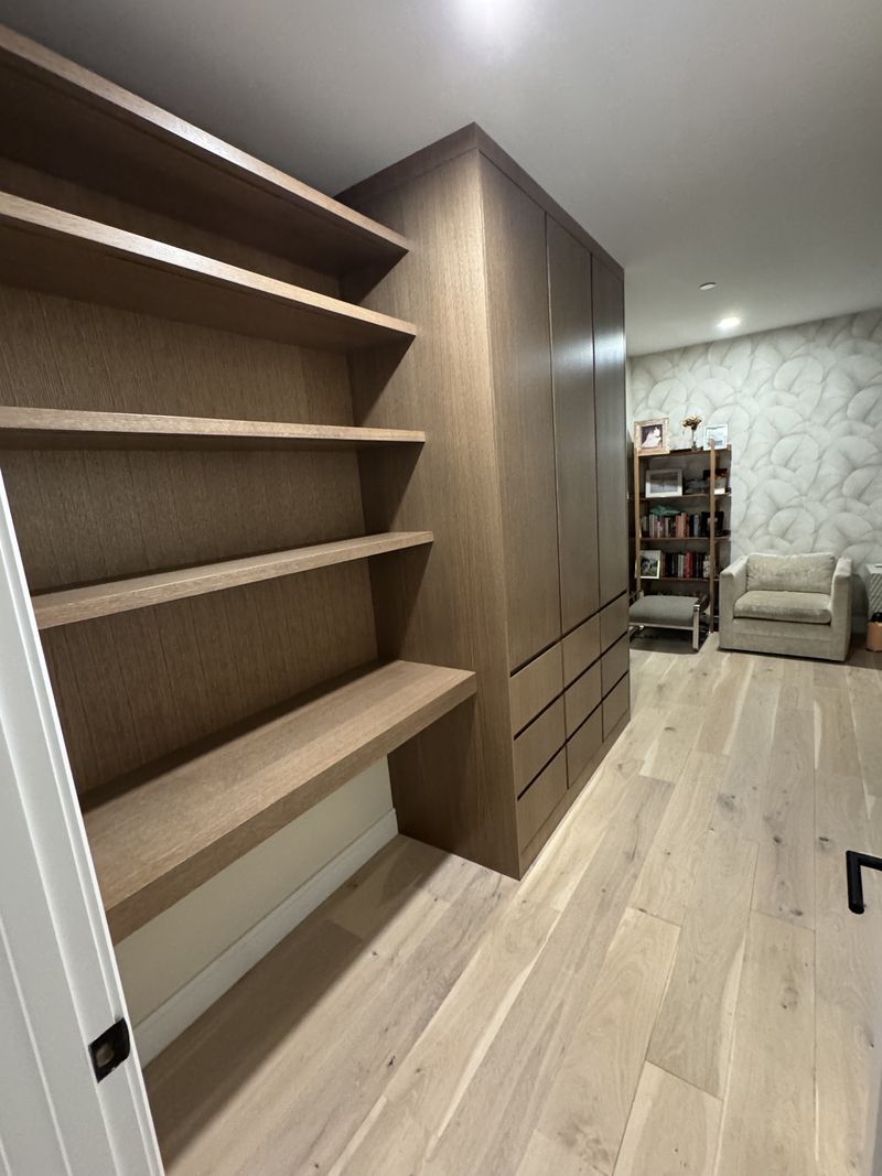 Custom built-in shelving and wardrobe cabinetry in white oak