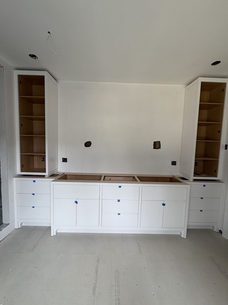 Custom built-in wall unit with open shelving and drawer bank