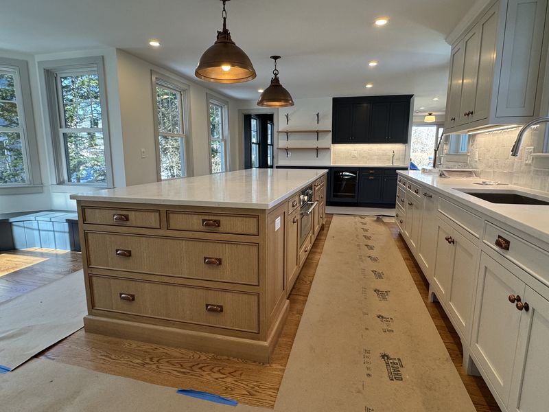 Long custom kitchen island in white oak with quartz countertop