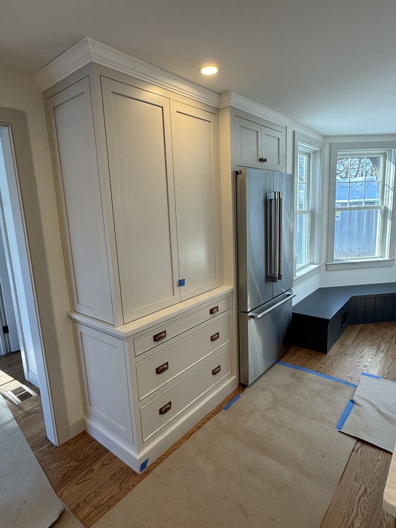 Custom tall pantry cabinet and panelled refrigerator surround