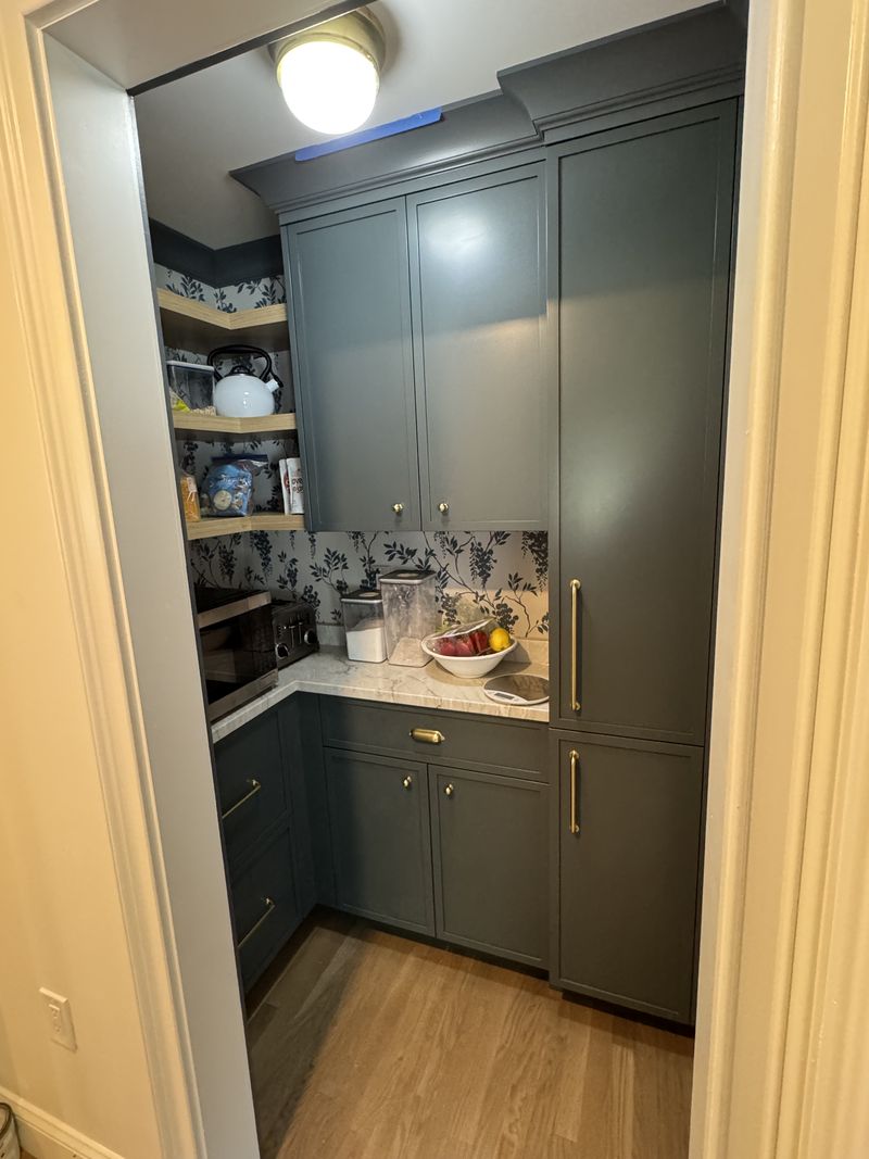 Custom forest green walk-in pantry with marble counter
