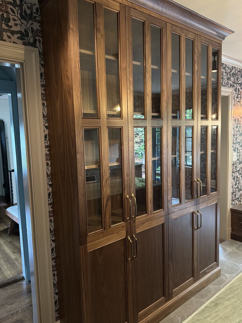 Custom walnut glass-front display cabinet with brass hardware