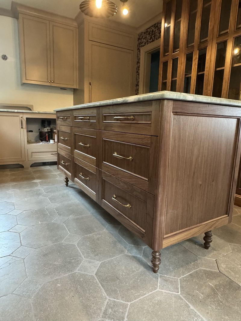 Custom walnut kitchen island with turned legs and stone countertop