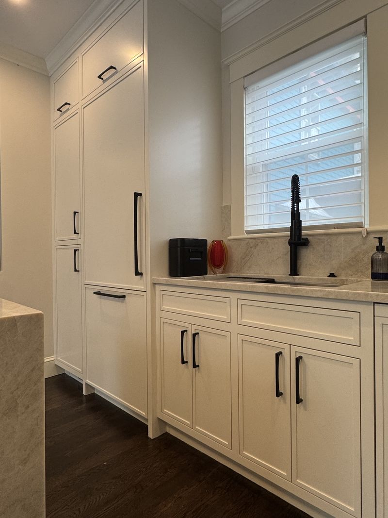 Custom white kitchen cabinetry with panel-ready refrigerator